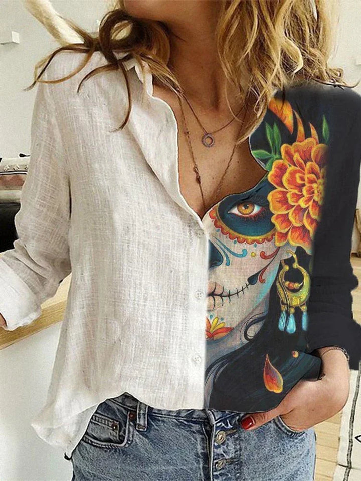 Woman wearing a half white button-up shirt and half black shirt with colorful Dia de los Muertos sugar skull face art and orange flower