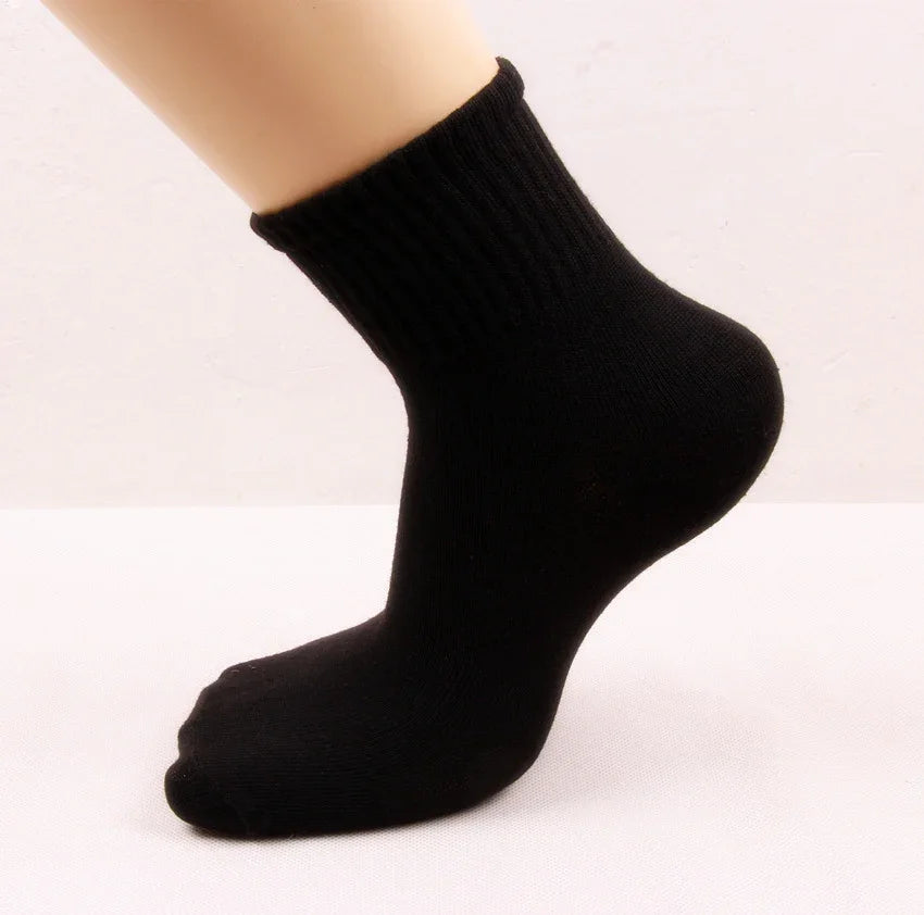 Black ankle sock on a mannequin foot against a neutral background