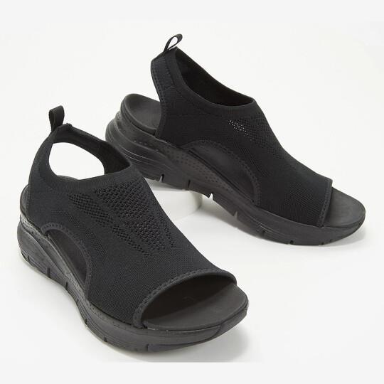 Black open-toe casual knit sneakers with thick sole and pull tabs on white background