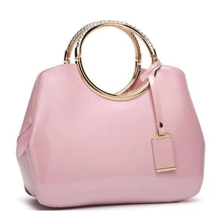 Elegant pink handbag with round gold metal handles and a matching pink tag