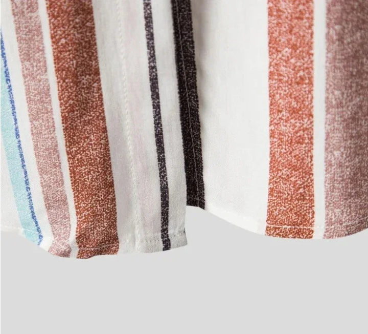 Close-up of fabric with vertical multicolor stripes in blue, brown, black, and white on a light background