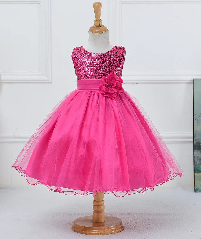 Bright pink girls' party dress with sequined bodice and tulle skirt on wooden dress form
