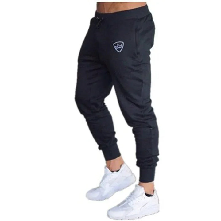 Black jogger pants with logo on thigh, worn with white athletic sneakers