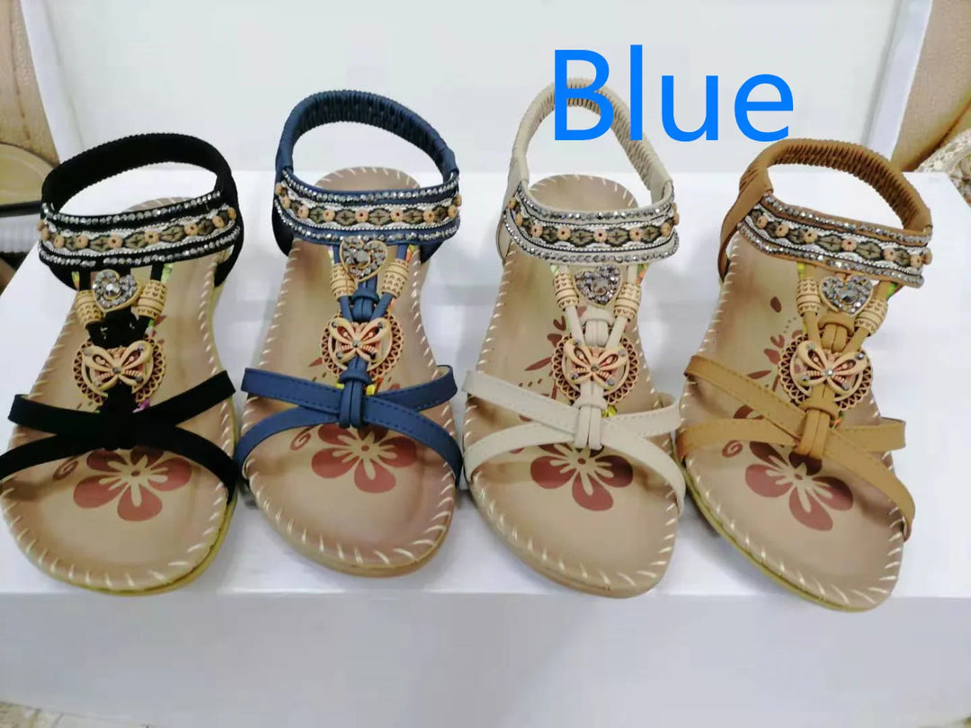Four pairs of embellished women's sandals in black, blue, white, and brown with floral patterns