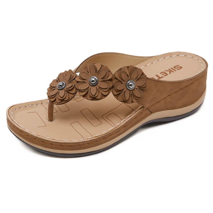 Brown women's wedge sandal with three flower decorations and toe post on beige sole