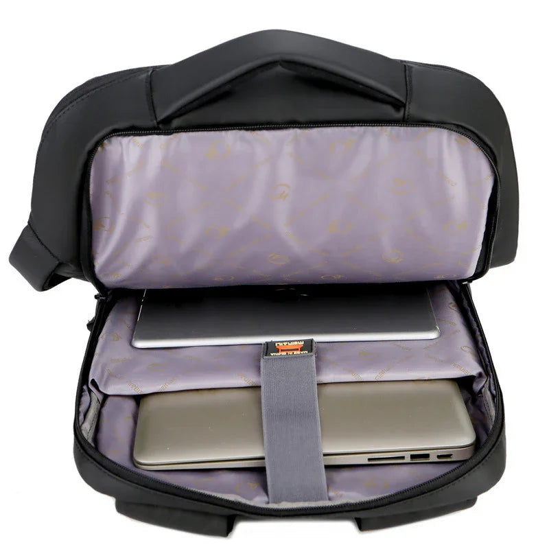 Black laptop backpack open showing padded compartments holding two laptops on gray interior lining