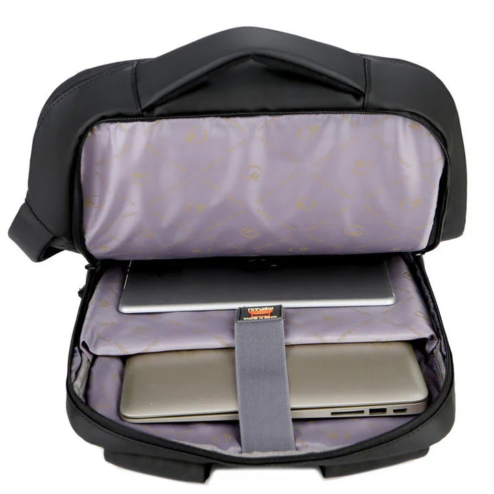 Black laptop backpack open showing padded compartments holding two laptops on gray interior lining