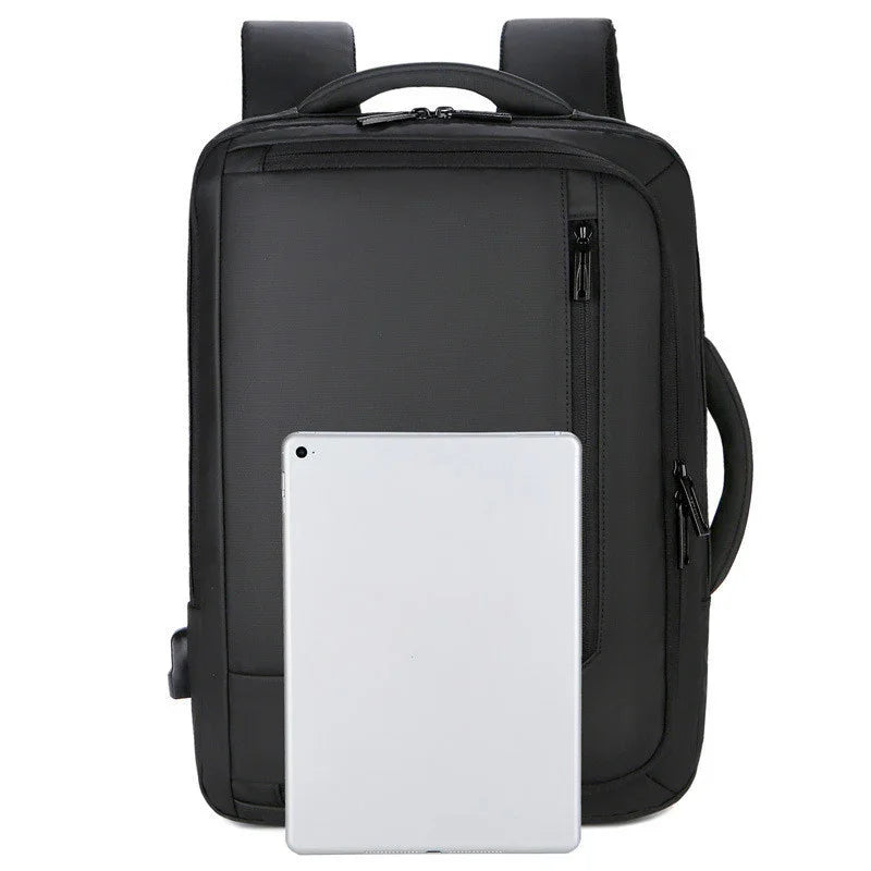 Black rectangular backpack with multiple zippered compartments and padded shoulder straps, tablet placed in front