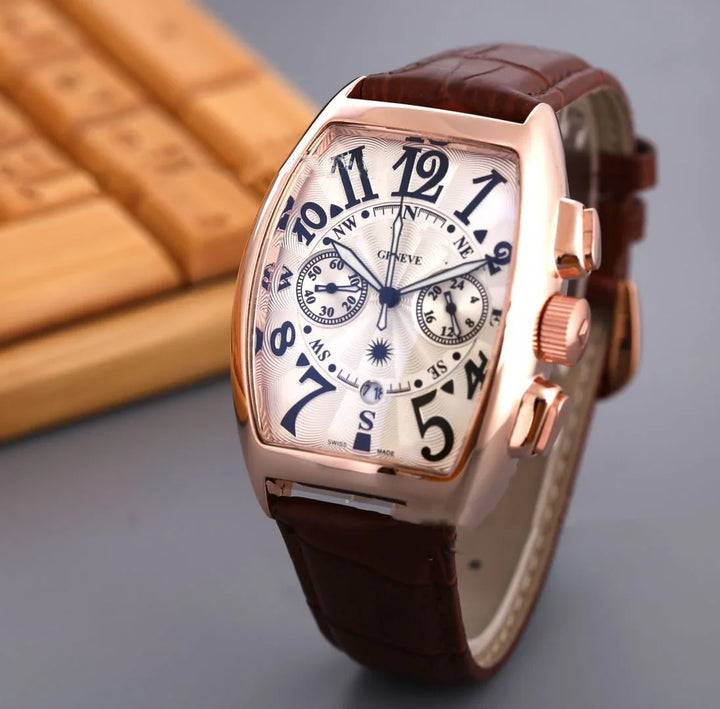 Rose gold rectangular wristwatch with white dial, black numerals, brown leather strap, dual subdials, and compass markings