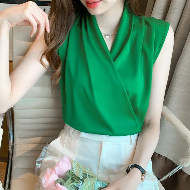 Woman wearing a sleeveless bright green blouse and white skirt, holding pink roses wrapped in cellophane