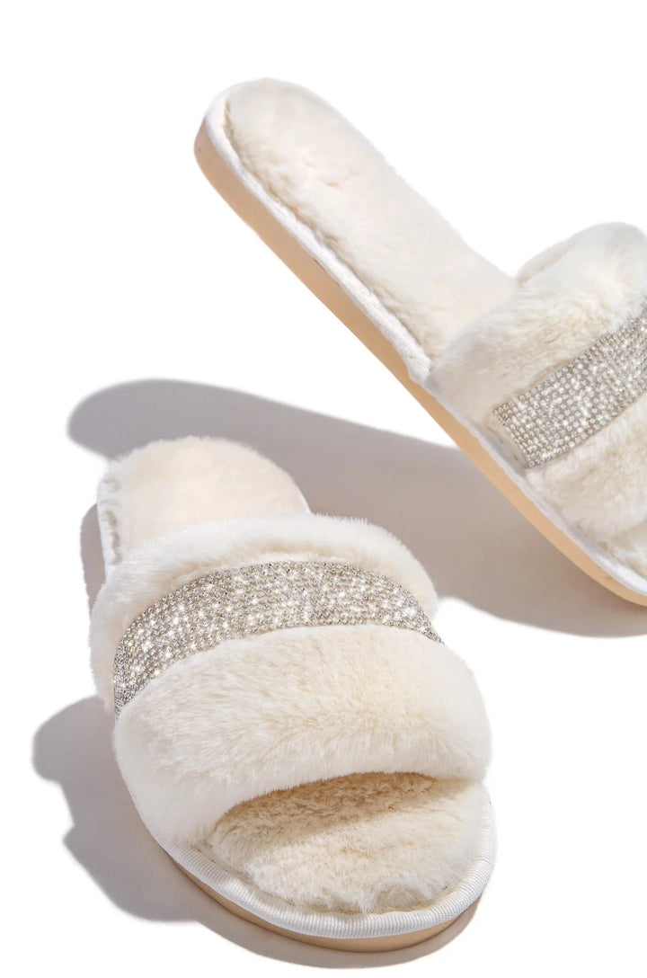 Soft cream faux fur slippers with rhinestone embellishments on white background