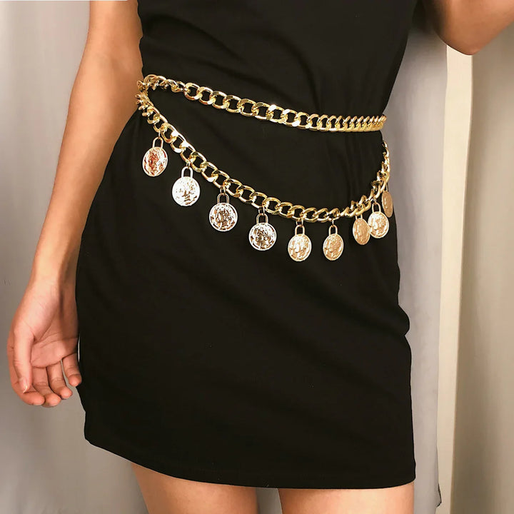 Gold chain belt with coin charms worn over a black dress on woman's waist