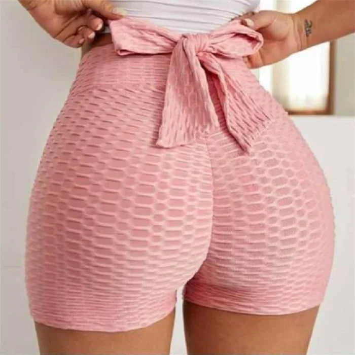Close-up of pink high-waisted textured workout shorts with a tied bow