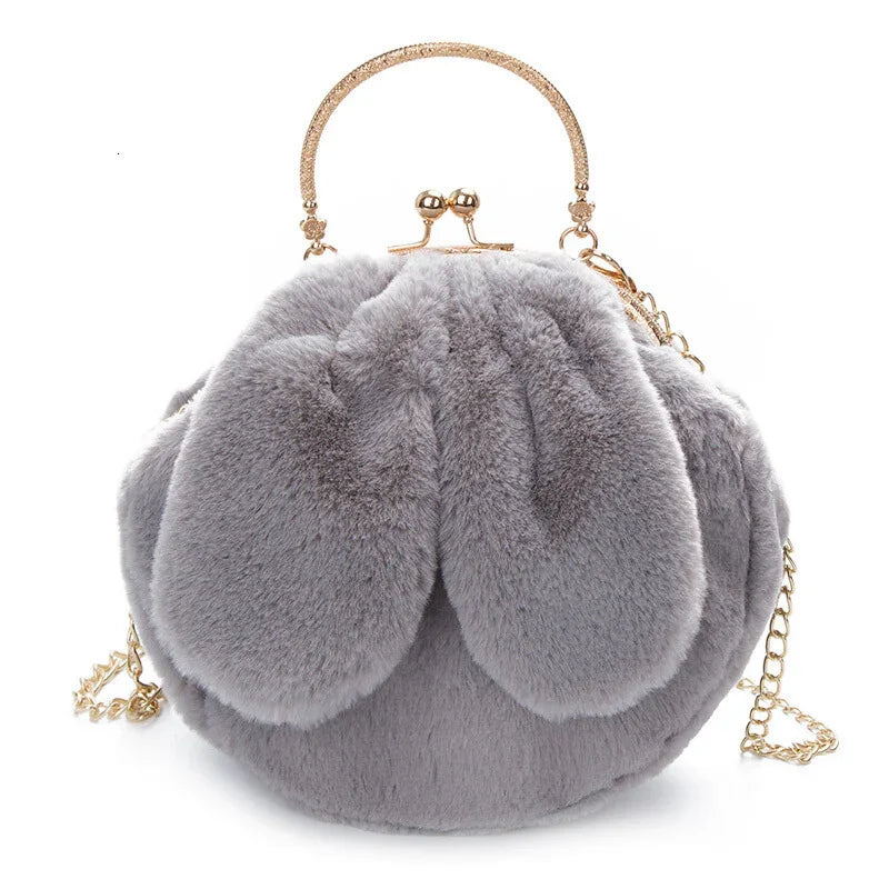 Grey fluffy faux fur handbag with gold clasp handle and chain strap against white background