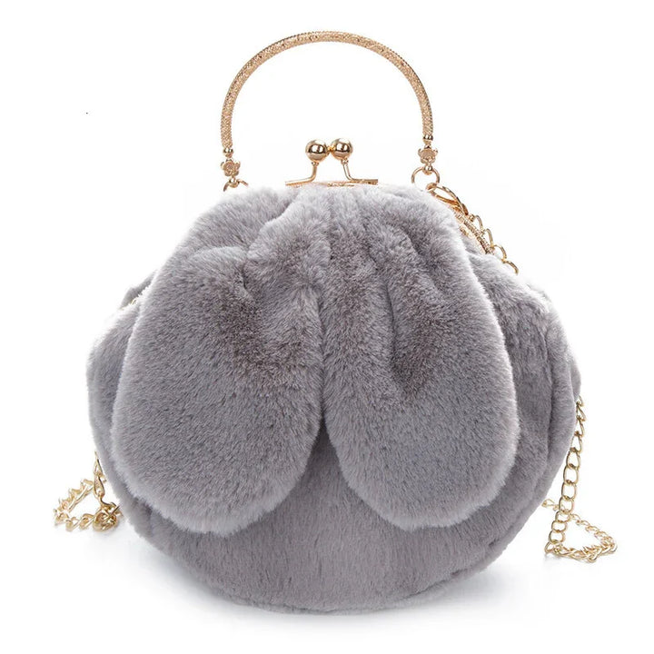 Grey fluffy faux fur handbag with gold clasp handle and chain strap against white background