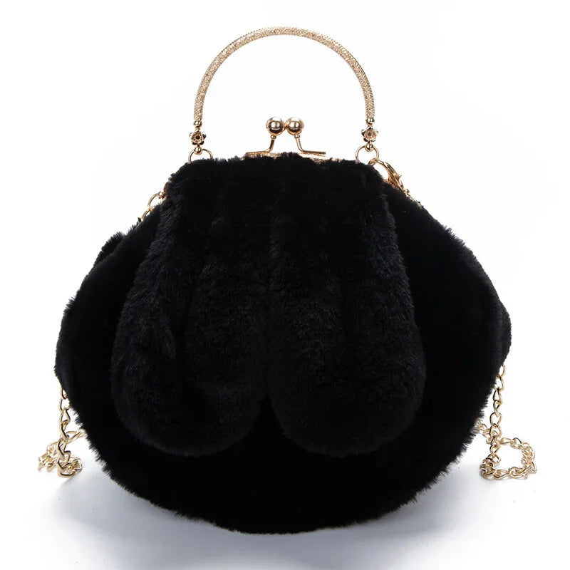 Black faux fur handbag with gold frame clasp, curved handle, and chain strap on white background