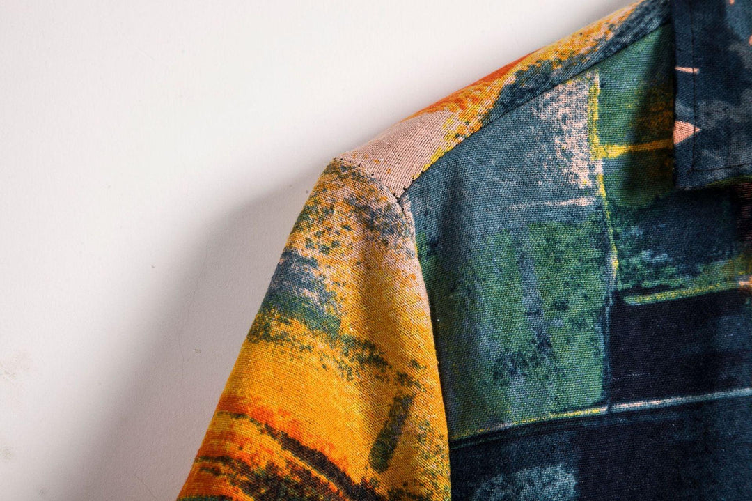 Close-up of a colorful fabric shirt shoulder with abstract blue, green, and orange patterns