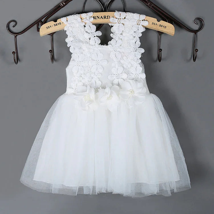 White sleeveless baby dress with floral lace bodice and tulle skirt hanging on wooden hanger