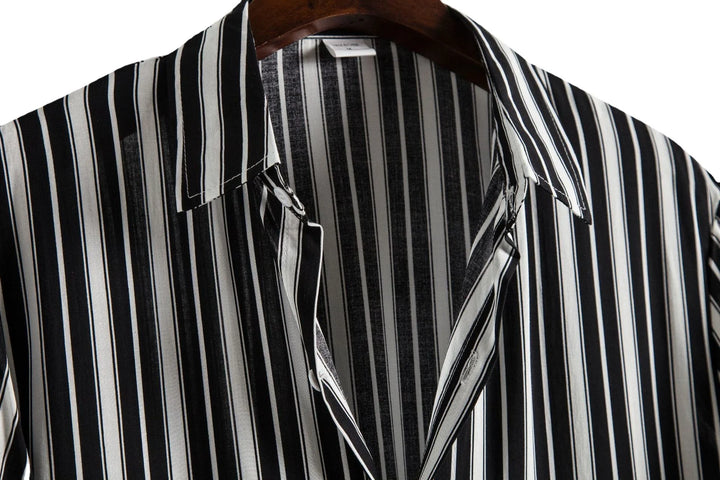 Black and white vertical striped button-up shirt on wooden hanger