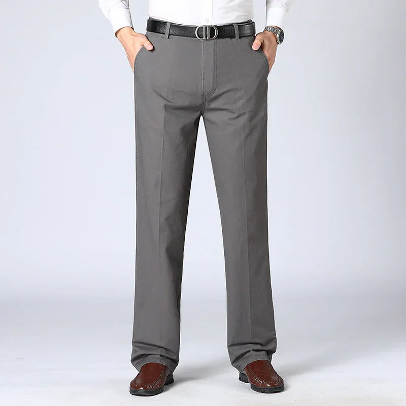 Man wearing gray dress pants, black belt with metal buckle, white shirt, and brown loafers