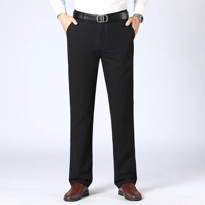 Man wearing black formal pants, brown leather shoes, black belt, and white shirt on white background