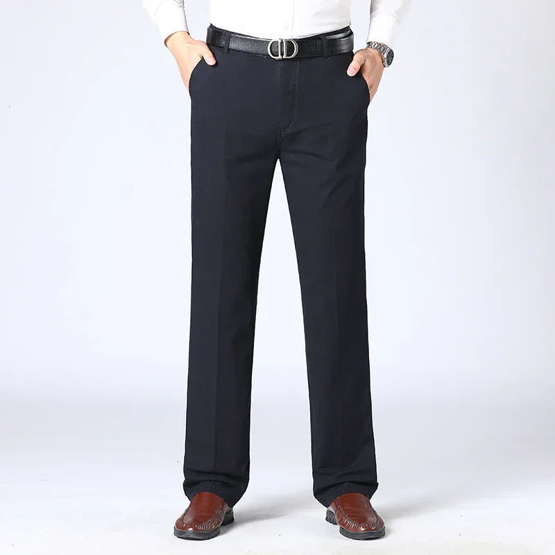 Man wearing black formal trousers with black belt and brown leather shoes against white background