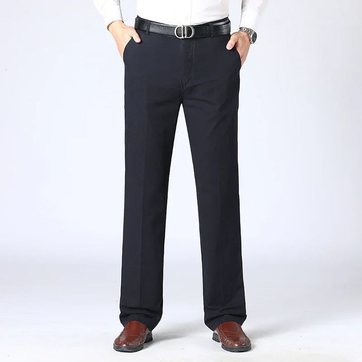 Man wearing black formal trousers with black belt and brown leather shoes against white background