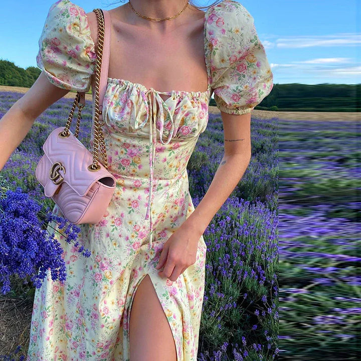 Woman in floral puff sleeve dress holding lavender bouquet and pink purse in lavender field