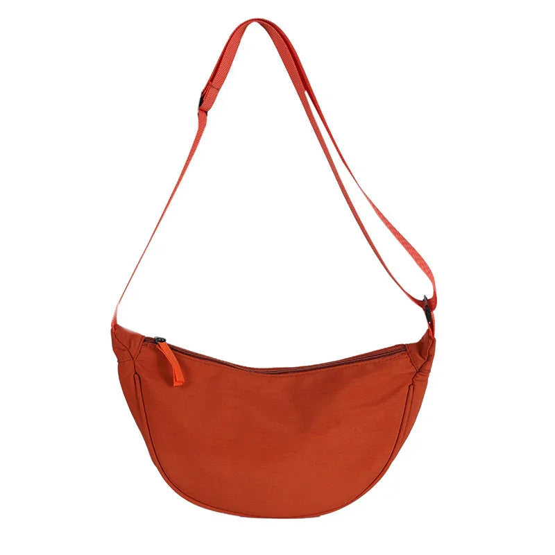 Minimalist burnt orange crossbody bag with adjustable strap and zipper closure