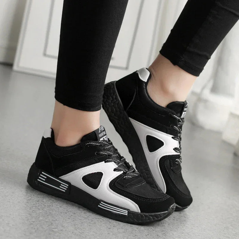 Black and white casual sneakers with textured soles worn with black leggings on gray floor