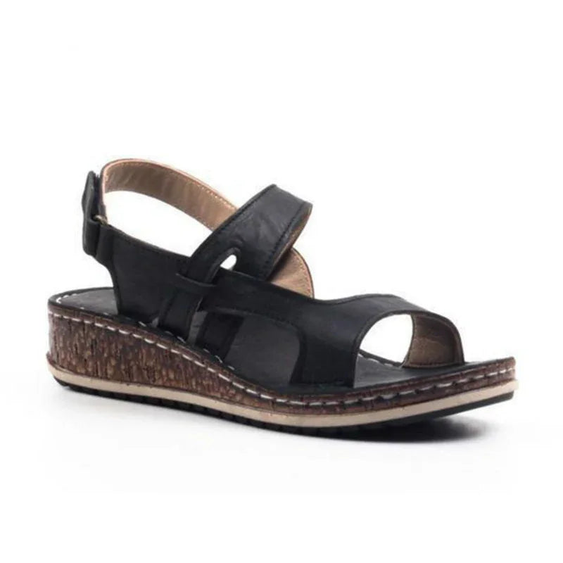 Black women’s wedge sandal with adjustable ankle strap and cork-textured sole