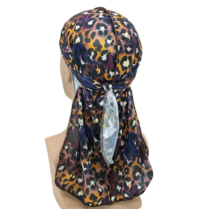 Leopard print satin durag with purple, orange, and black spots tied at the back on mannequin