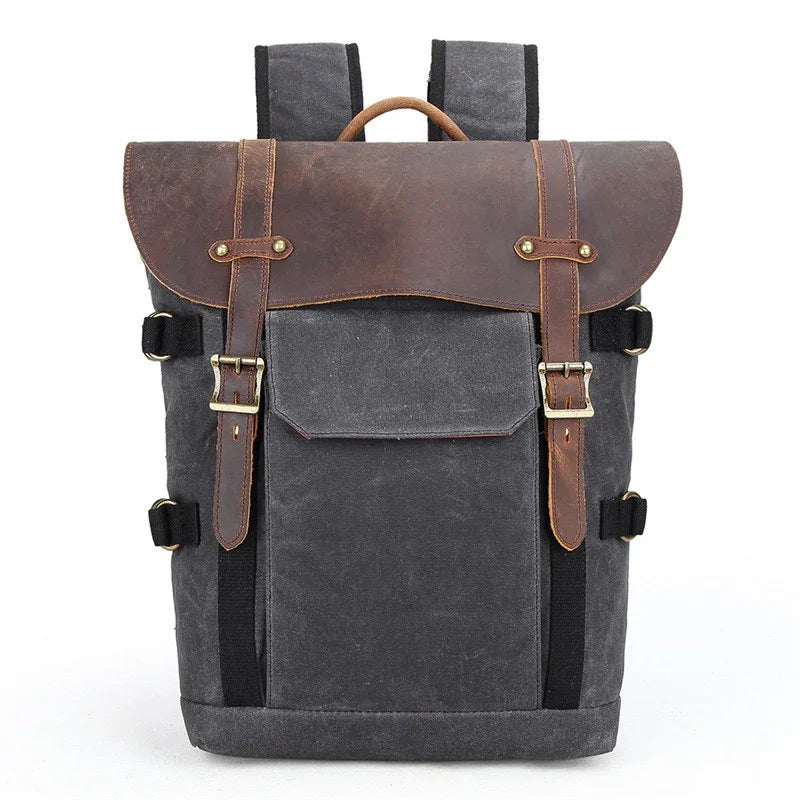 Stylish black canvas backpack with brown leather flap, adjustable straps, and front pocket on white background