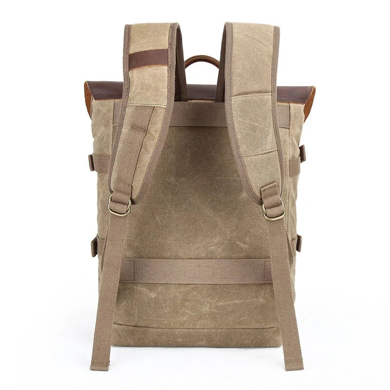 Back view of beige canvas backpack with padded straps and leather accents on white background