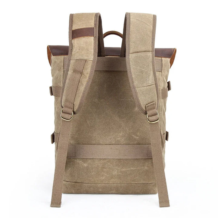 Back view of beige canvas backpack with padded straps and leather accents on white background