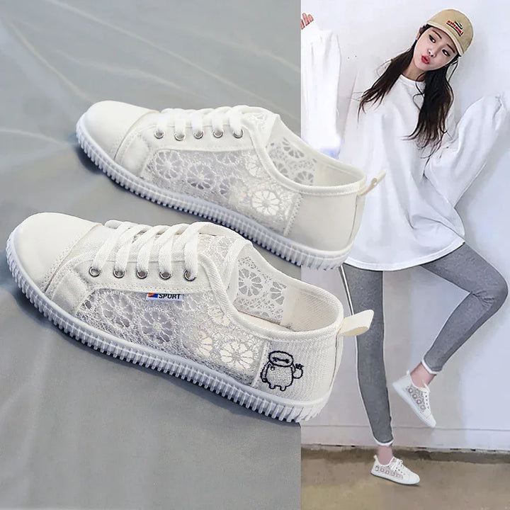 White lace casual sneakers with cartoon detail worn by woman in white oversized shirt and gray leggings