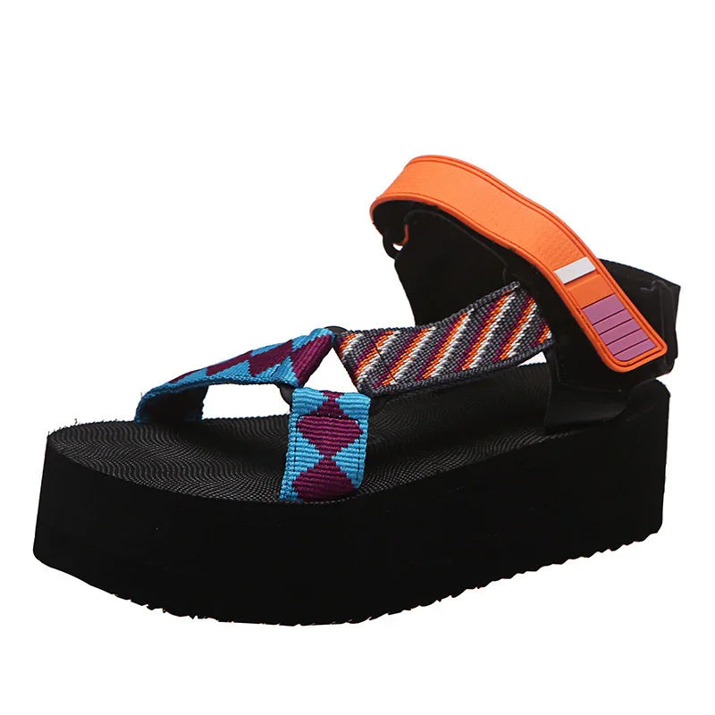 Black platform sandal with blue, purple, and orange patterned straps and an orange ankle strap