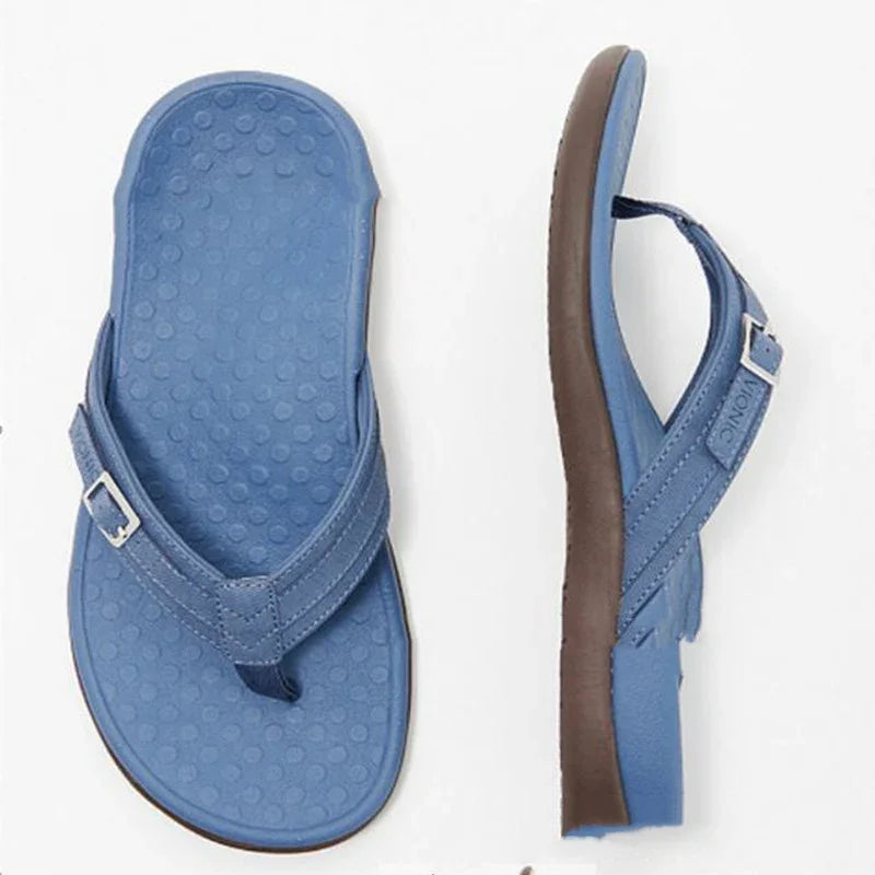 Blue thong sandals with adjustable buckle straps and textured footbed on white background
