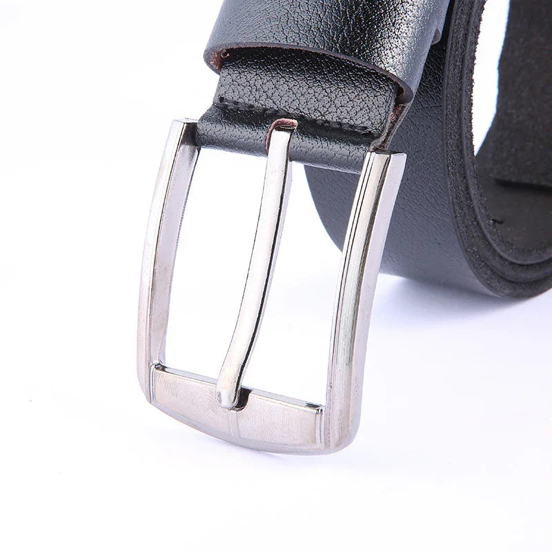 Close-up of black leather belt with silver metal buckle on white background