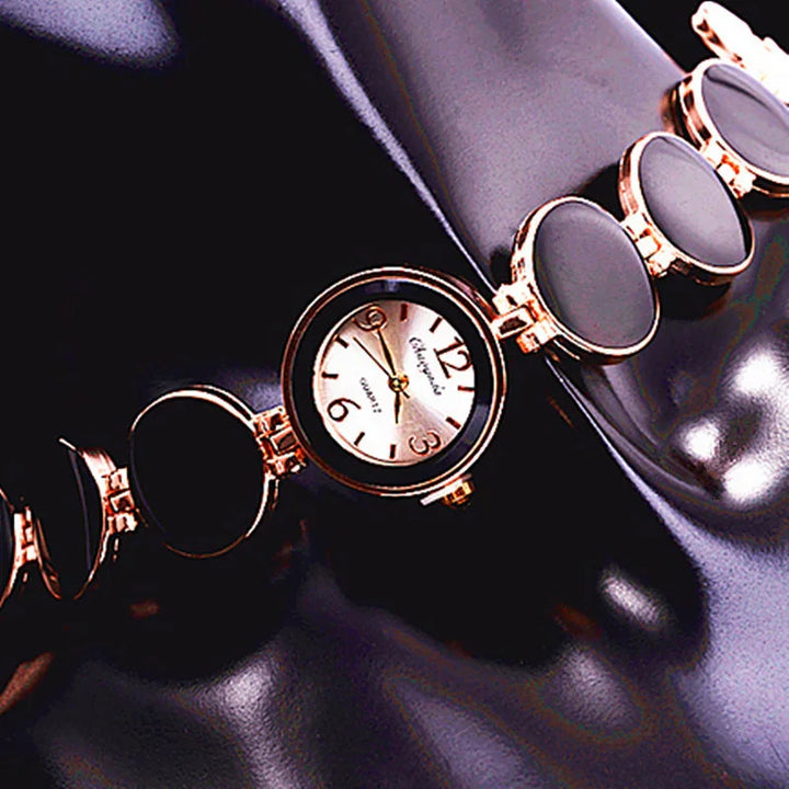 Elegant black and gold round-faced wristwatch with protective flip covers on glossy black surface