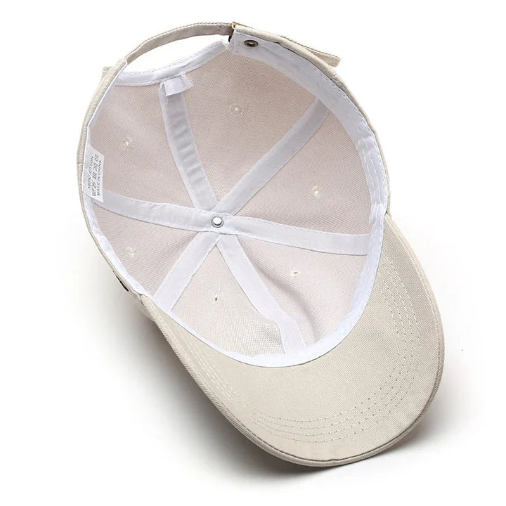 Inside view of beige cotton baseball cap showing white inner lining and adjustable strap