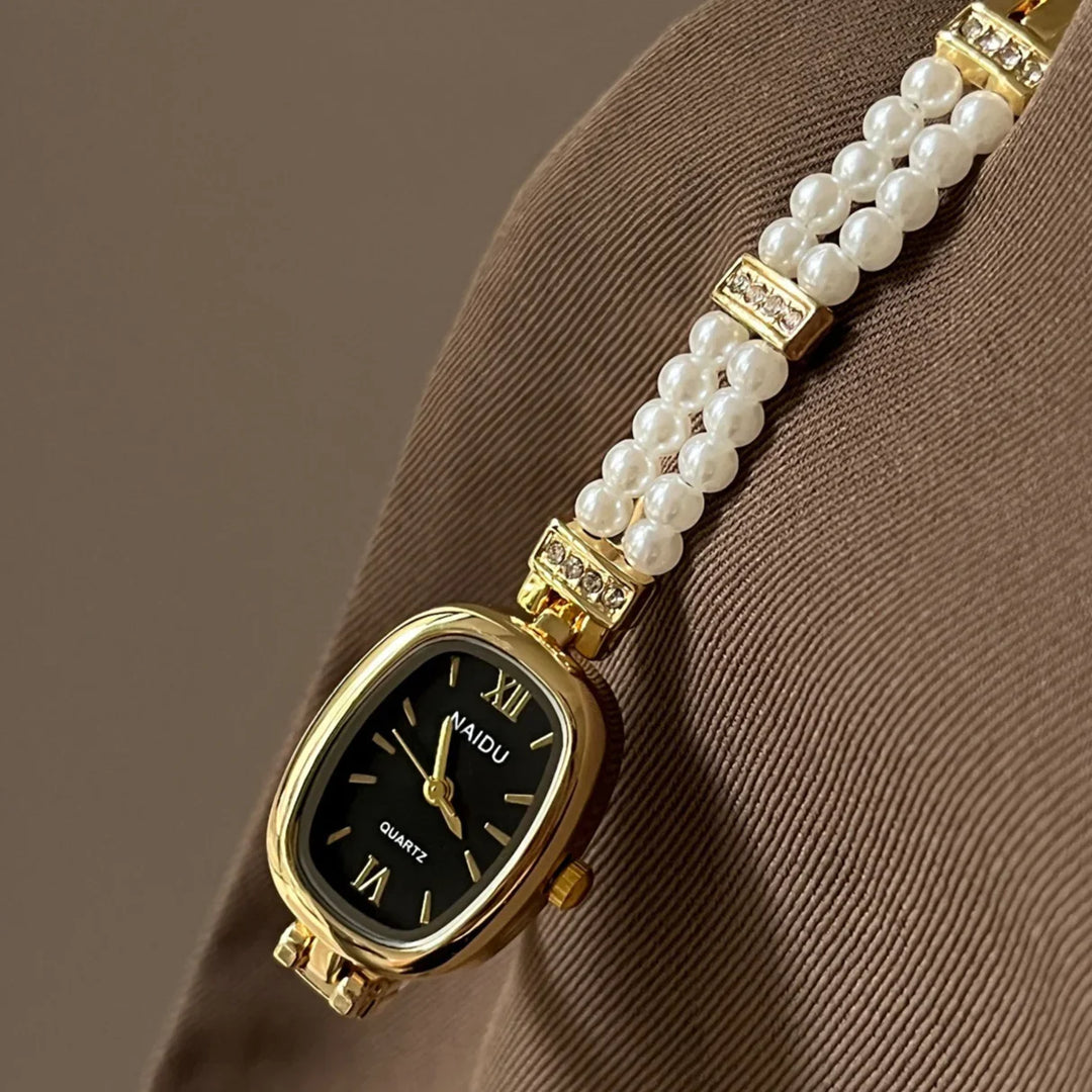 Elegant gold NAIDU quartz wristwatch with black dial and pearl bracelet detail