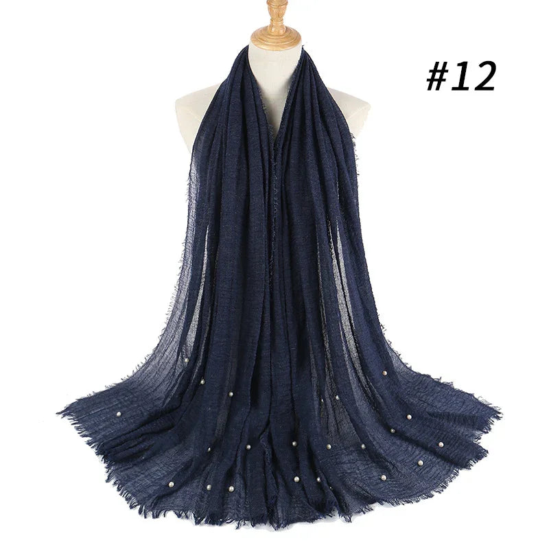 Dark navy blue scarf with pearl embellishments displayed on mannequin against white background