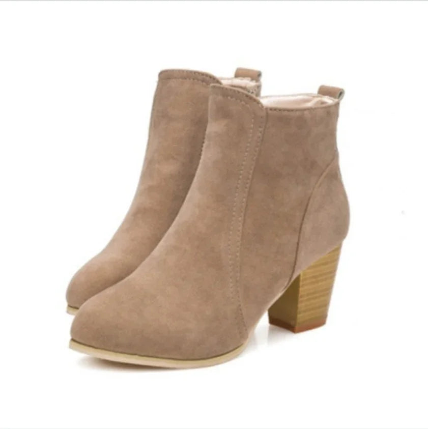 Pair of beige suede ankle boots with block heels on white background