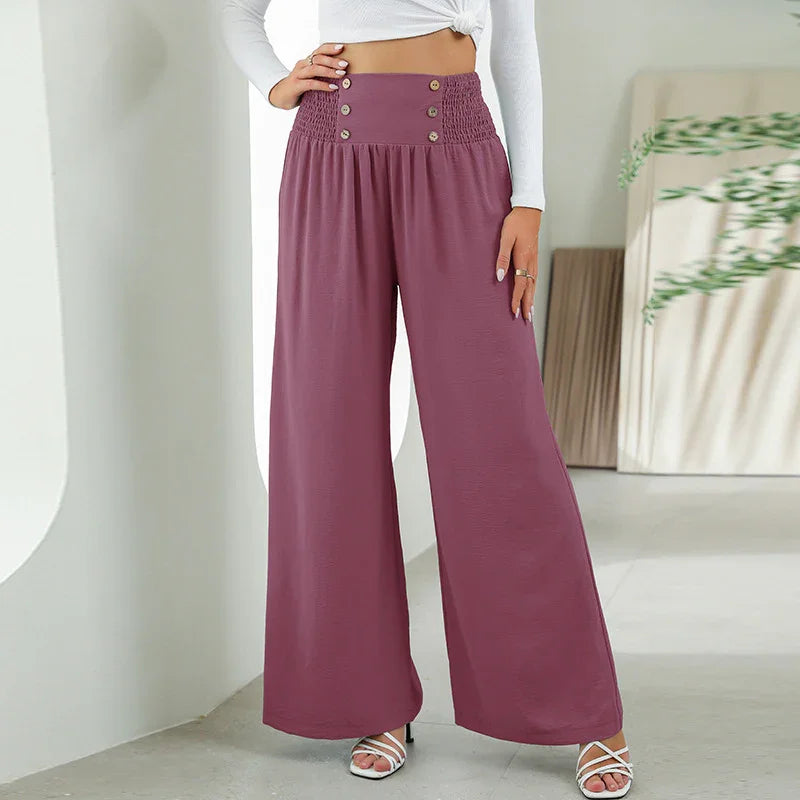 Woman wearing mauve wide-leg pants with button detail and high smocked waist, white top and heels