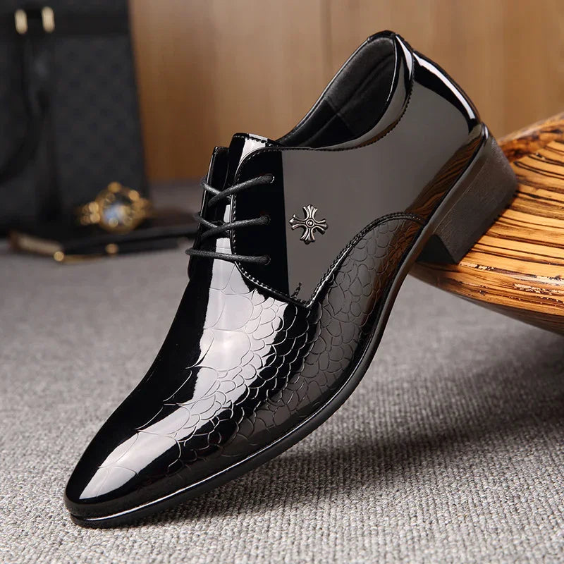 Elegant black men's patent leather dress shoe with scale texture and metal emblem detail