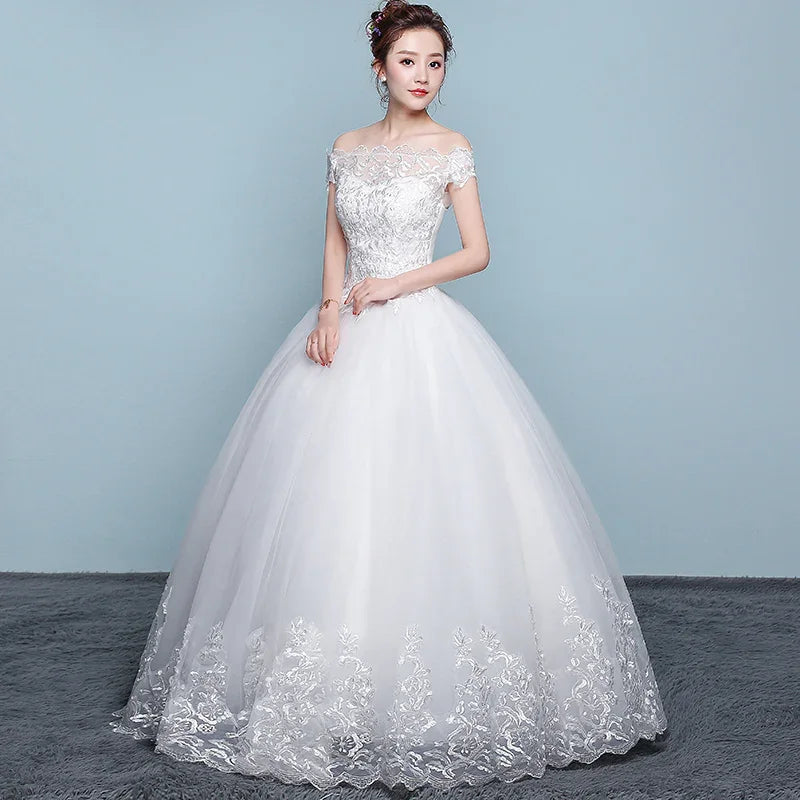 Bride in elegant off-shoulder white lace wedding gown with floral embroidery on skirt