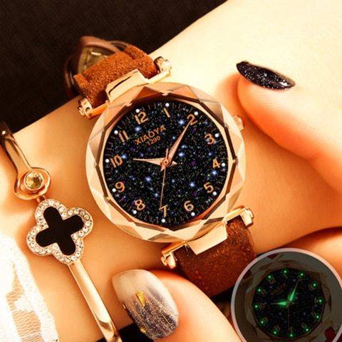 XIAOYA luxury women's wristwatch with sparkling black dial and brown leather strap on wrist