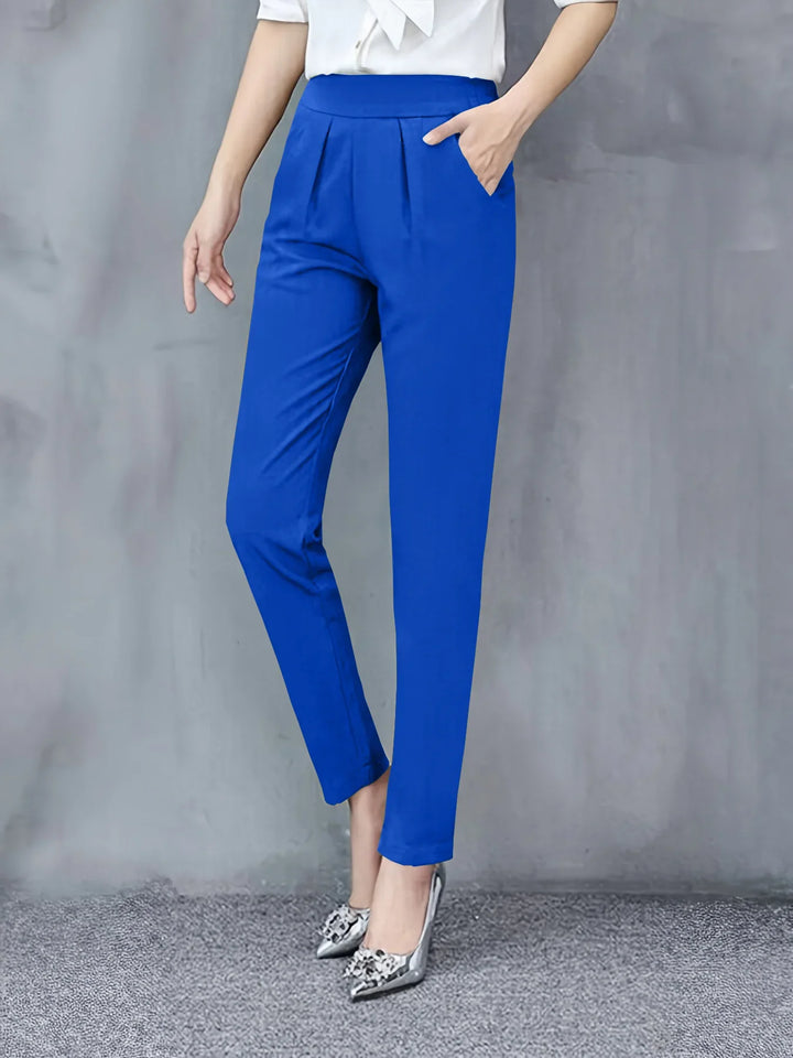 Woman wearing bright blue tailored slim-fit trousers with pockets and silver high heels
