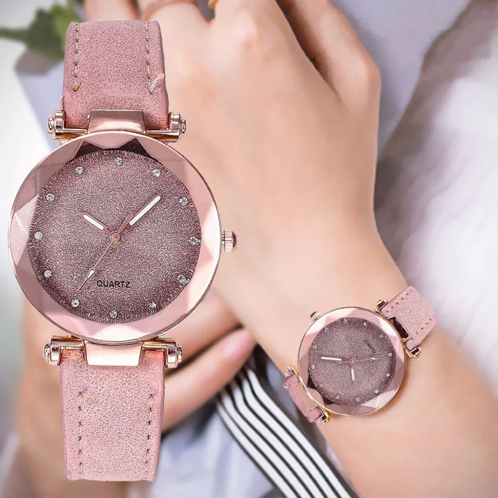 Women's pink quartz watch with glittering dial and suede strap on wrist